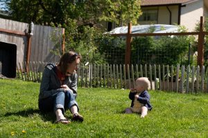 Kristin Page and her baby Fern play in their backyard that is filled with herbs, chickens, and vegetables. Photo by Emily Porter